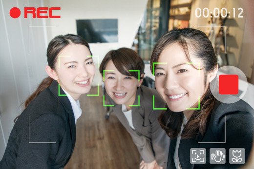 Three women take a video selfie while the camera software frames their faces with square outlines.