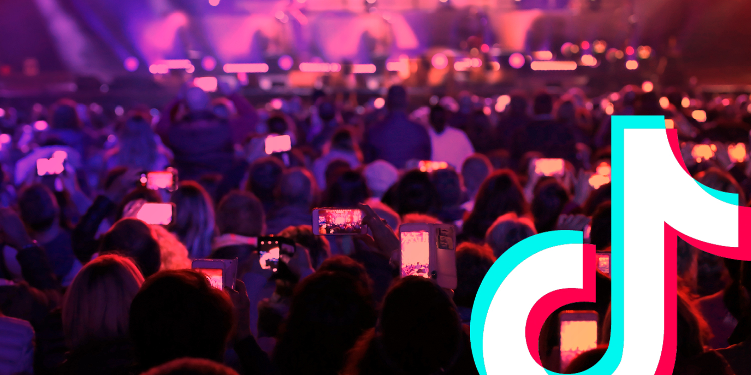 An audience facing a stage, with many holding up smartphones, overlayed with the TikTok logo.